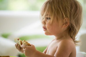 young child eating a sandwich